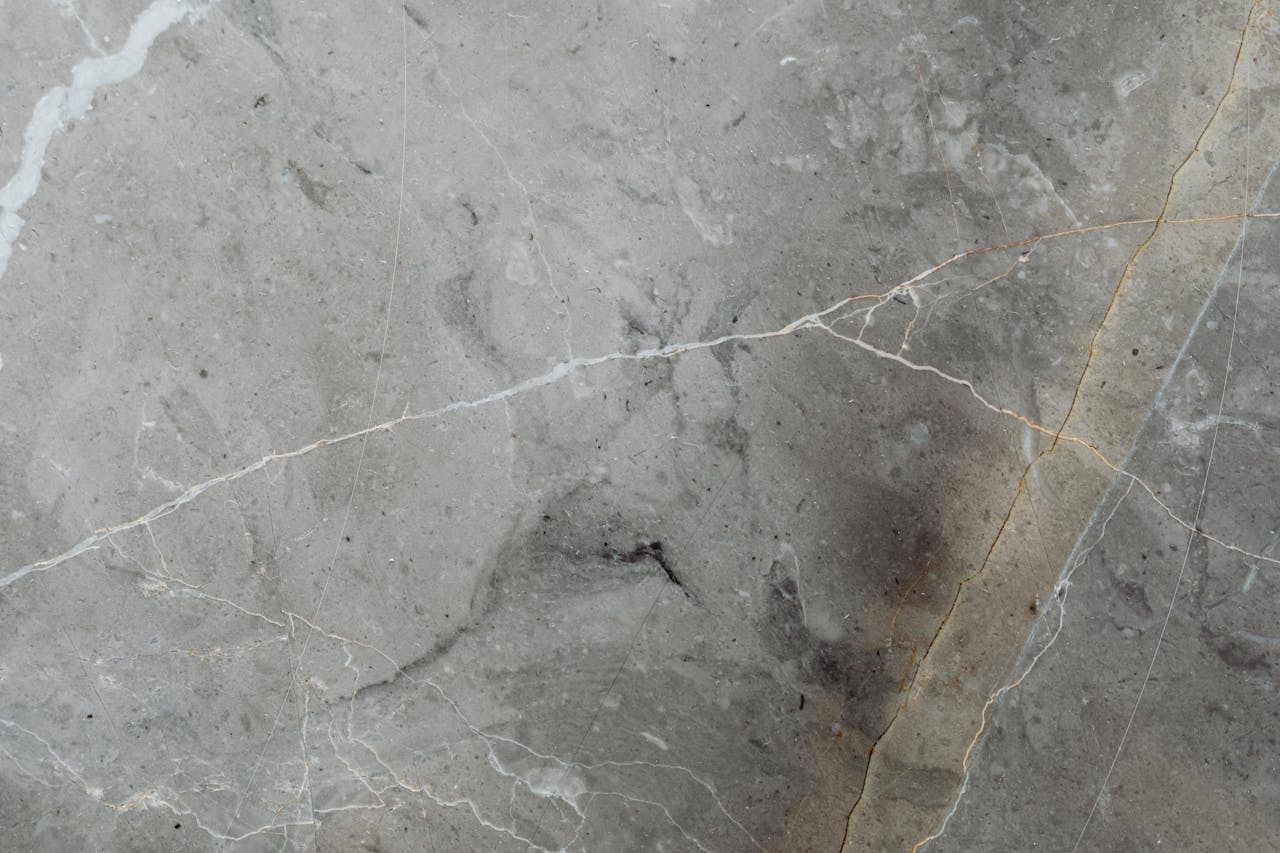 Detailed close-up of a gray stone surface showing natural veins and textures.